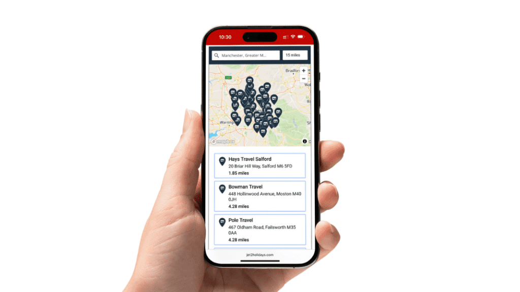 Hand holding a smartphone displaying the Jet2 agency finder tool, showing travel agents near Manchester on a map.