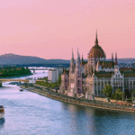 River cruise ship passing Budapest’s Parliament building at sunset, capturing the elegance and cultural highlights of river cruising in Europe.