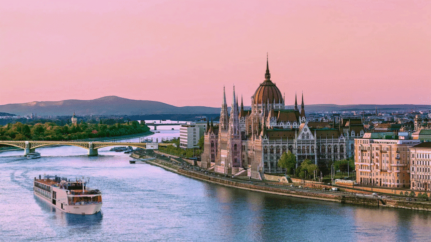 River cruise ship passing Budapest’s Parliament building at sunset, capturing the elegance and cultural highlights of river cruising in Europe.